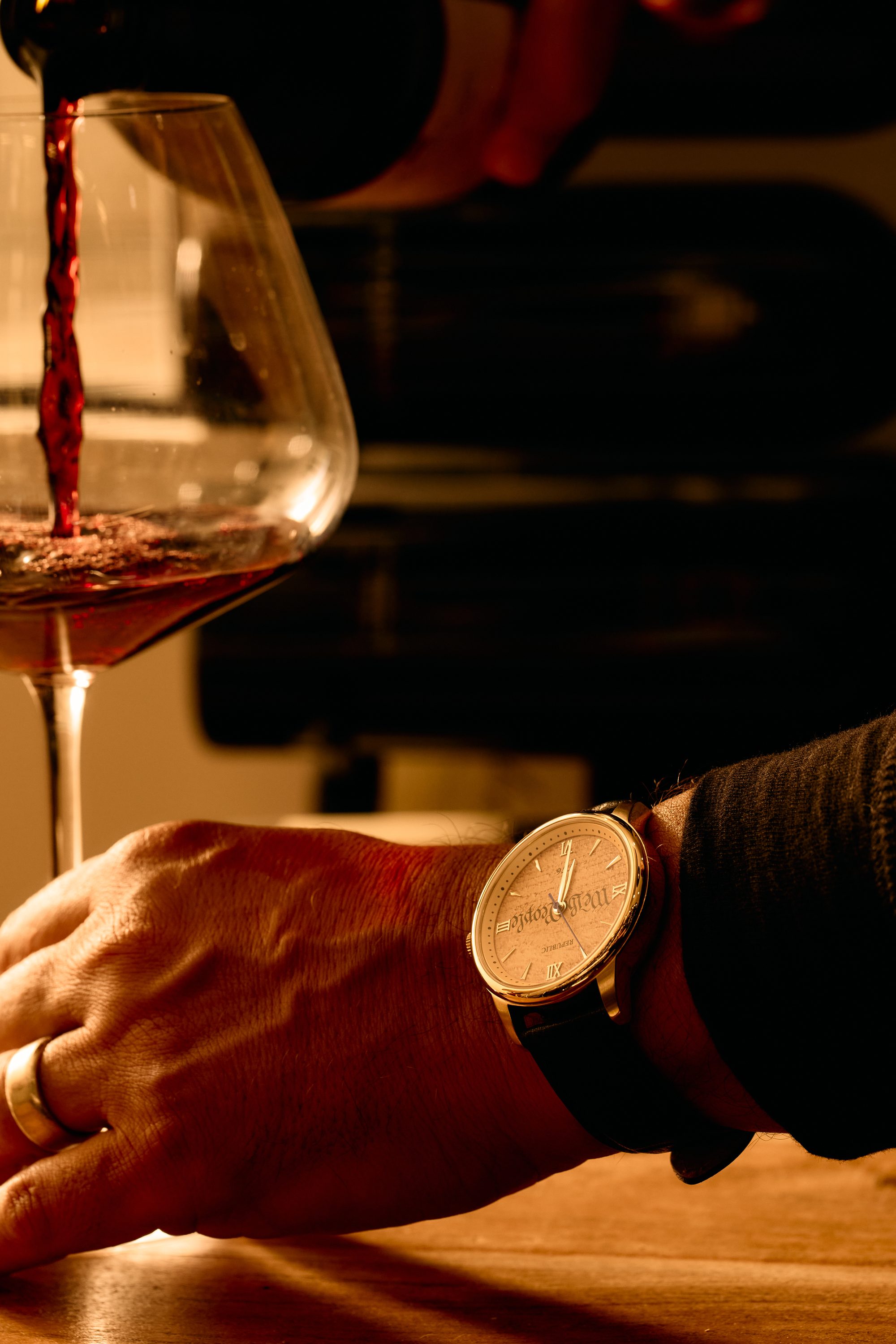 The We The People timepiece worn at the table as wine is poured